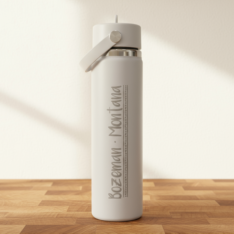 off-White water bottle with 'Bozeman Montana' text on a wooden surface