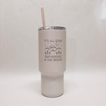 White tumbler with an engraved design with mountains and trees and the words "It's all good in the woods"