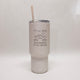 White tumbler with an engraved design with mountains and trees and the words "It's all good in the woods"