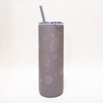 Gray tumbler with leaf patterns and a straw on a white background