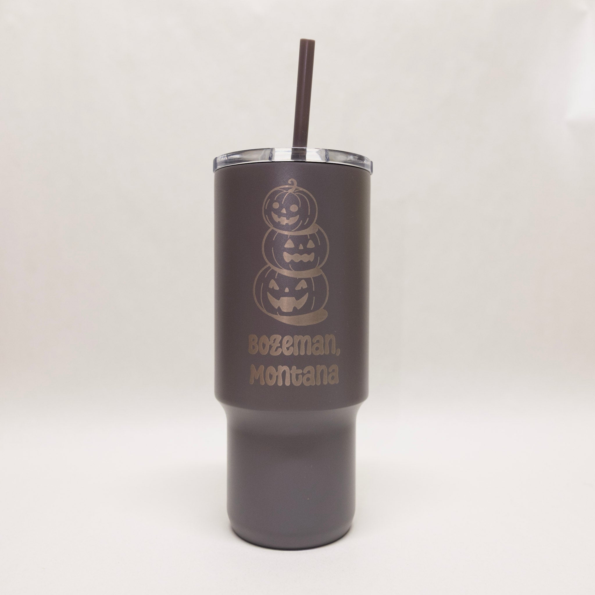 Dark gray tumbler with Halloween design and 'Bozeman, Montana' text on a white background