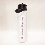 White water bottle with black cap and 'Bozeman, Montana' text on a light beige background