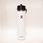 White Hydro Flask water bottle with black lid on a light beige background