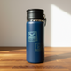 Blue insulated bottle with a logo on a wooden surface