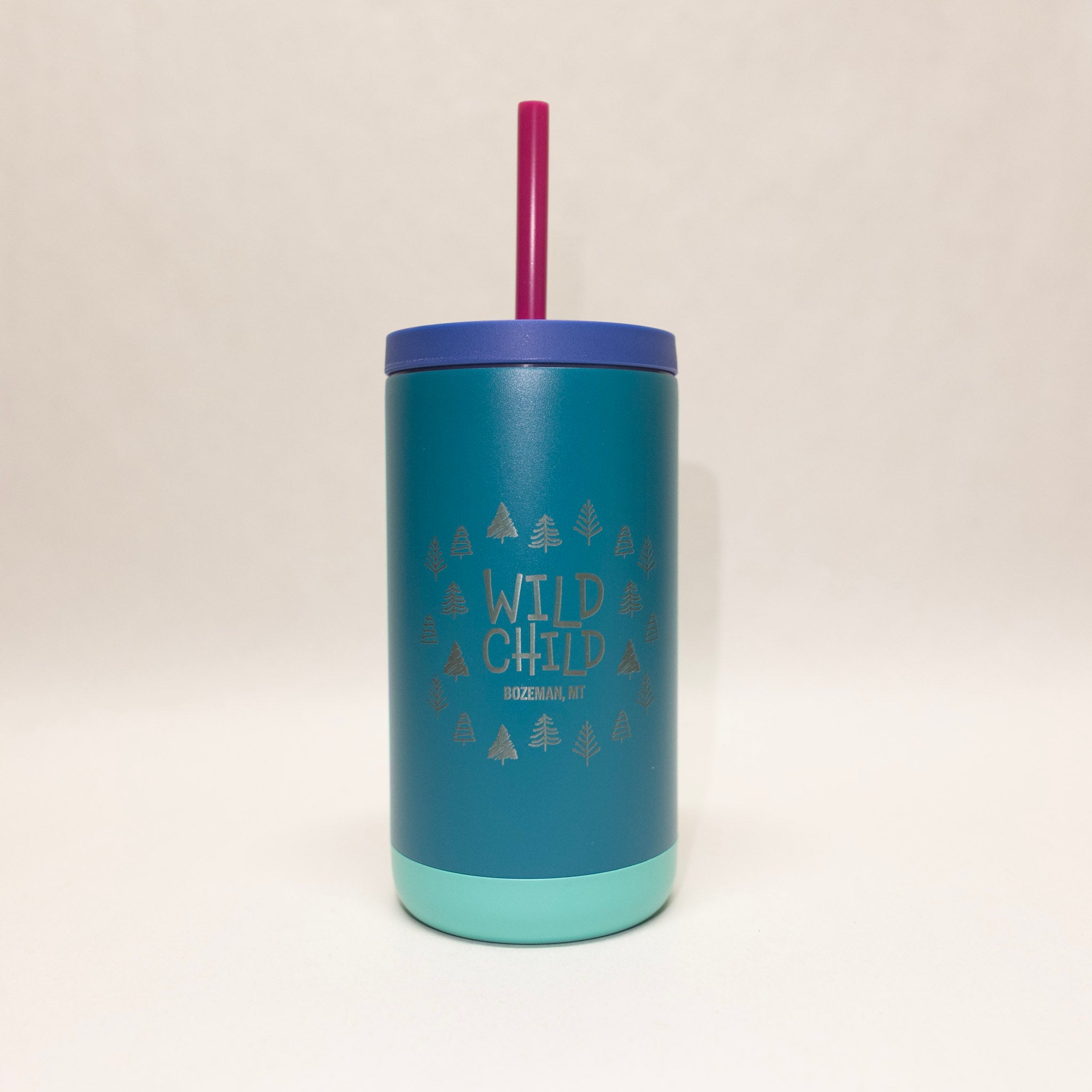 Blue tumbler with 'Wild Child' text and purple straw on a beige background
