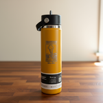 Yellow water bottle with black lid on a wooden surface