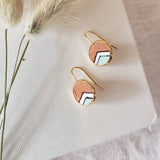 Pair of earrings with circular design on a textured surface