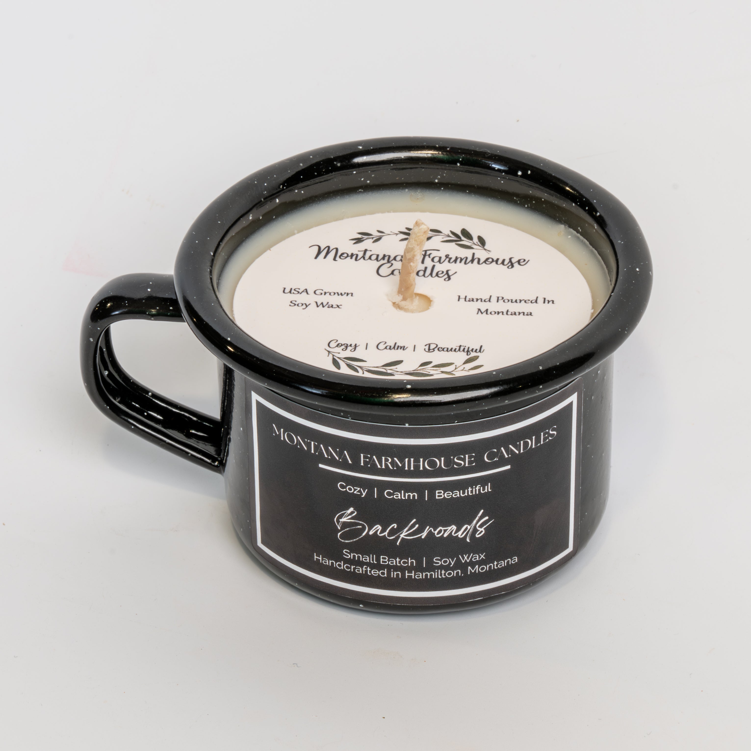 Black mug with a candle labeled 'Montana Farmhouse Candles' on a light gray background