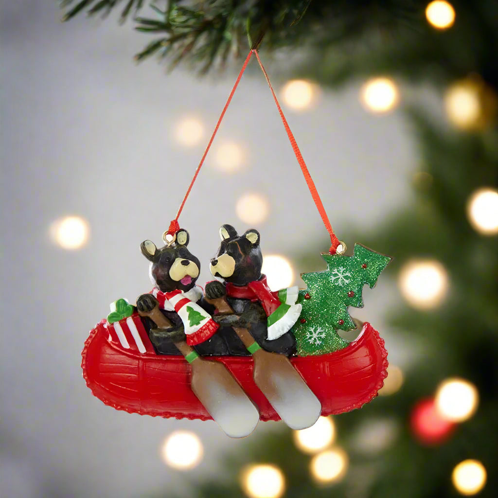 Christmas ornament of two bears in a red canoe with a Christmas tree and presents.
