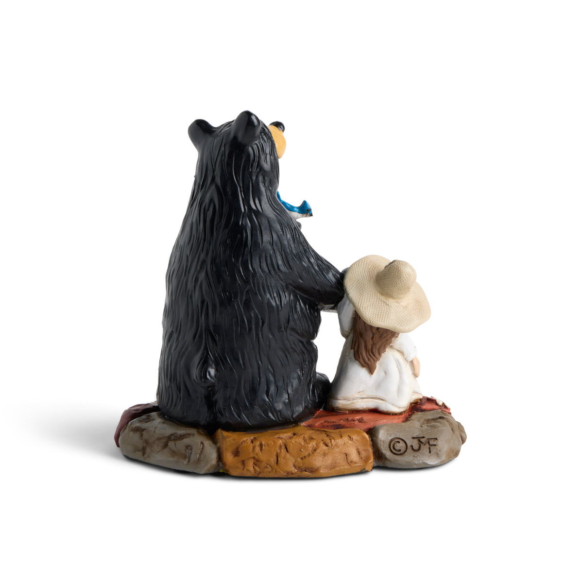 Bear and child figurine sitting on rocks with a white background