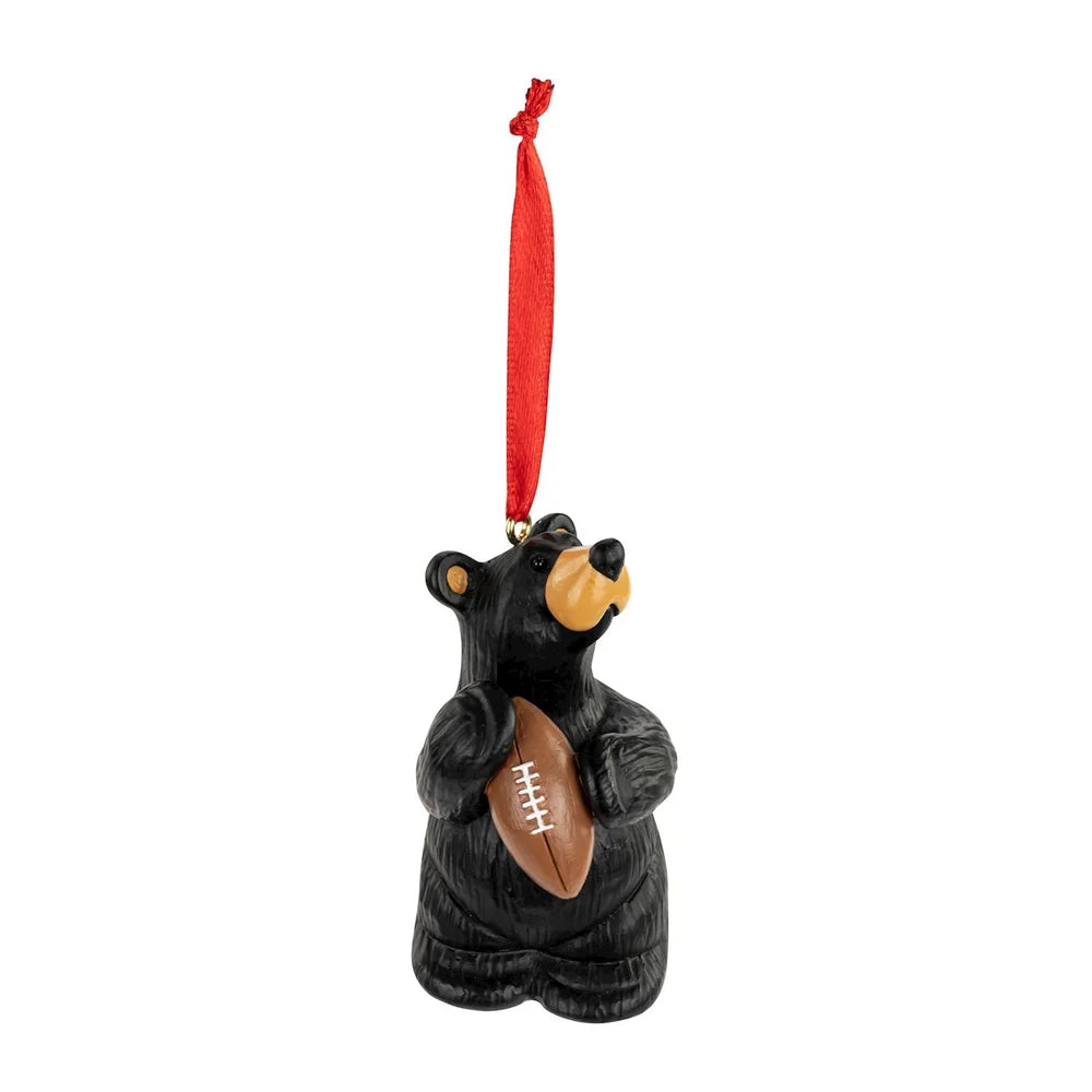 Black bear ornament holding a football with a red ribbon on a white background