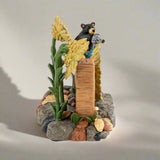 Decorative figurine of a bear with flowers and rocks on a white background