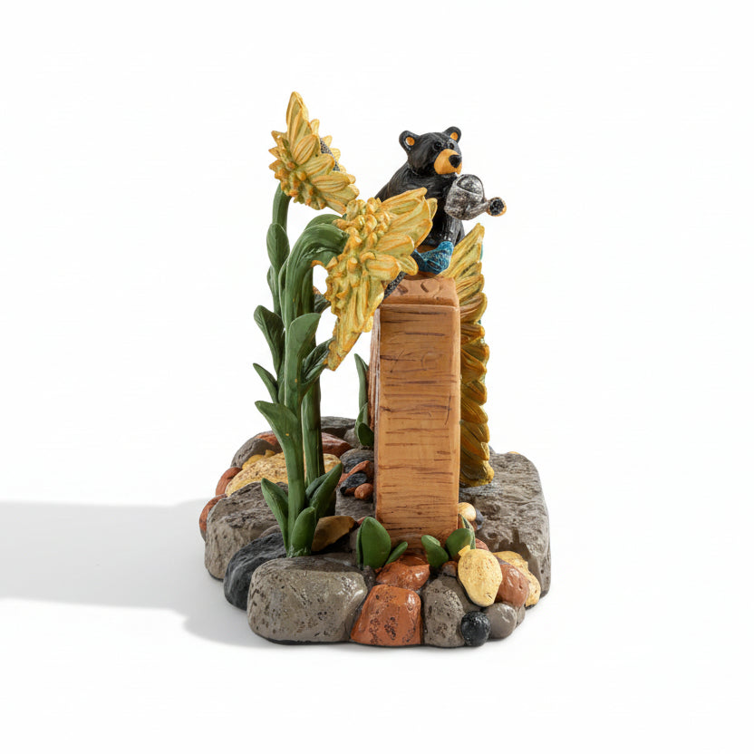 Decorative figurine of a bear with flowers and rocks on a white background