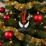 Black dog toy with white wings and a red ribbon on a white background