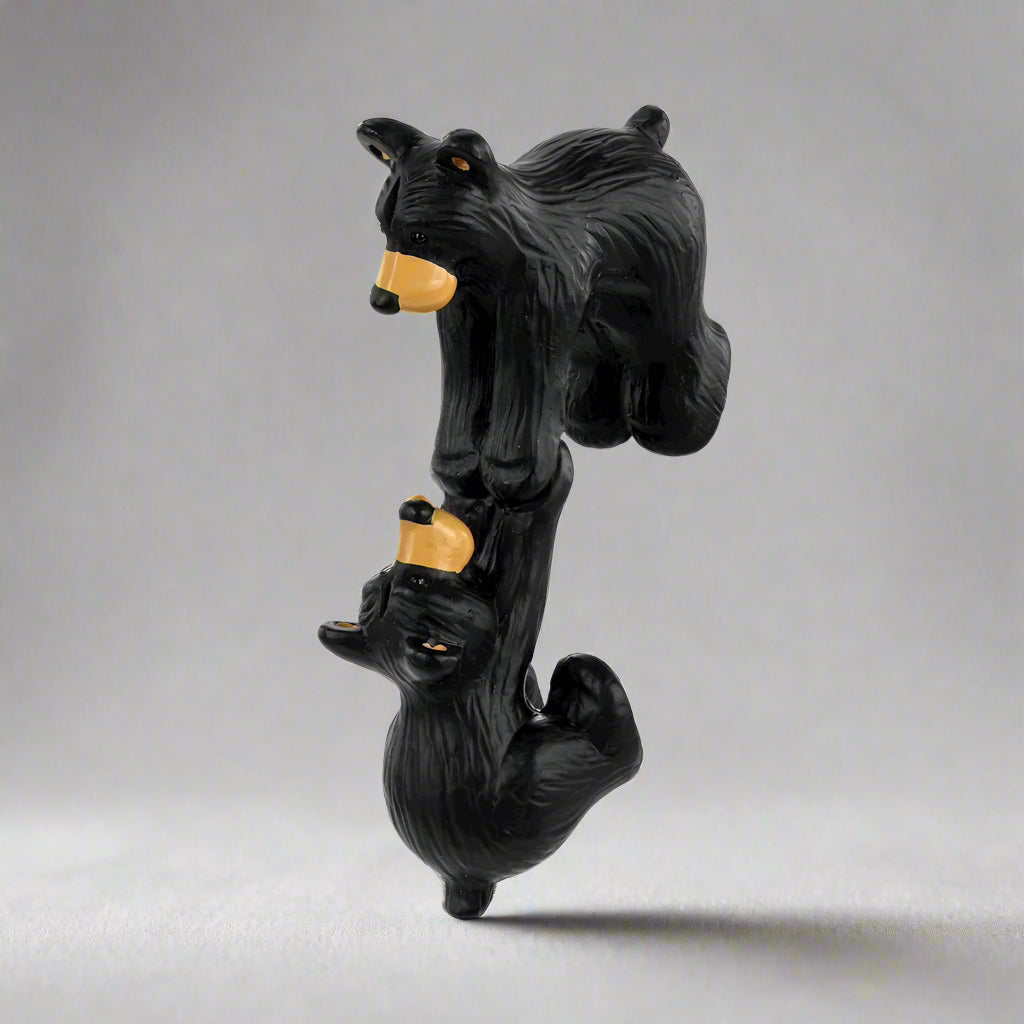 Black bear figurine with a yellow nose on a white background