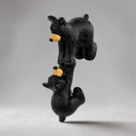 Black bear figurine with a yellow nose on a white background