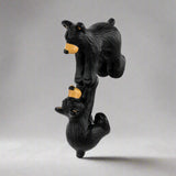 Black bear figurine with a yellow nose on a white background