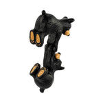 Back side of two black bear figurines hanging together