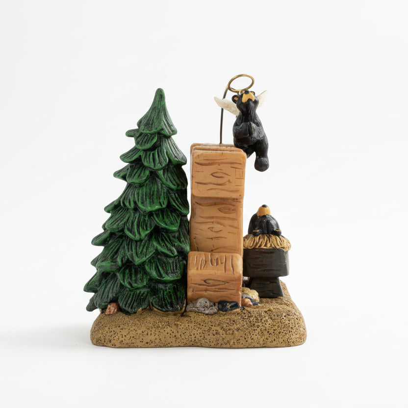 Decorative figurine with a tree, log, and bear on a white background