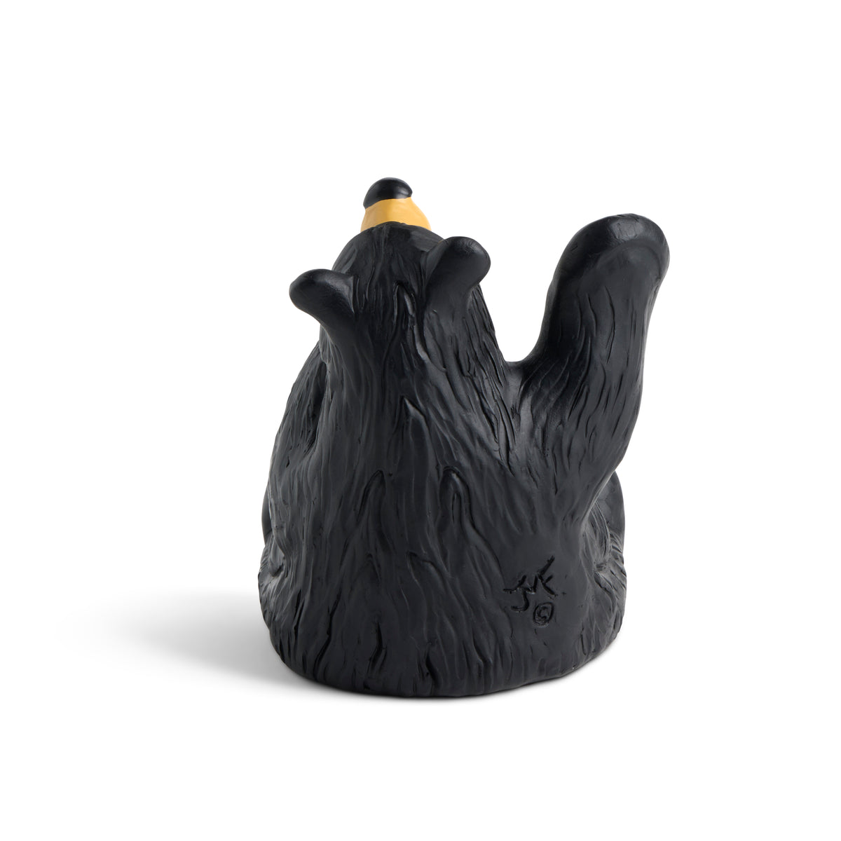 Black bear figurine with gold paw pads on a white background