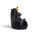 Black bear figurine with yellow nose on a white background
