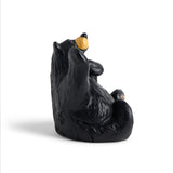 Black bear figurine with yellow nose on a white background