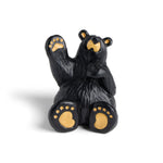 Black bear figurine with gold paw pads on a white background