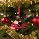 Christmas ornament of a red truck with bears and a tree on a white background
