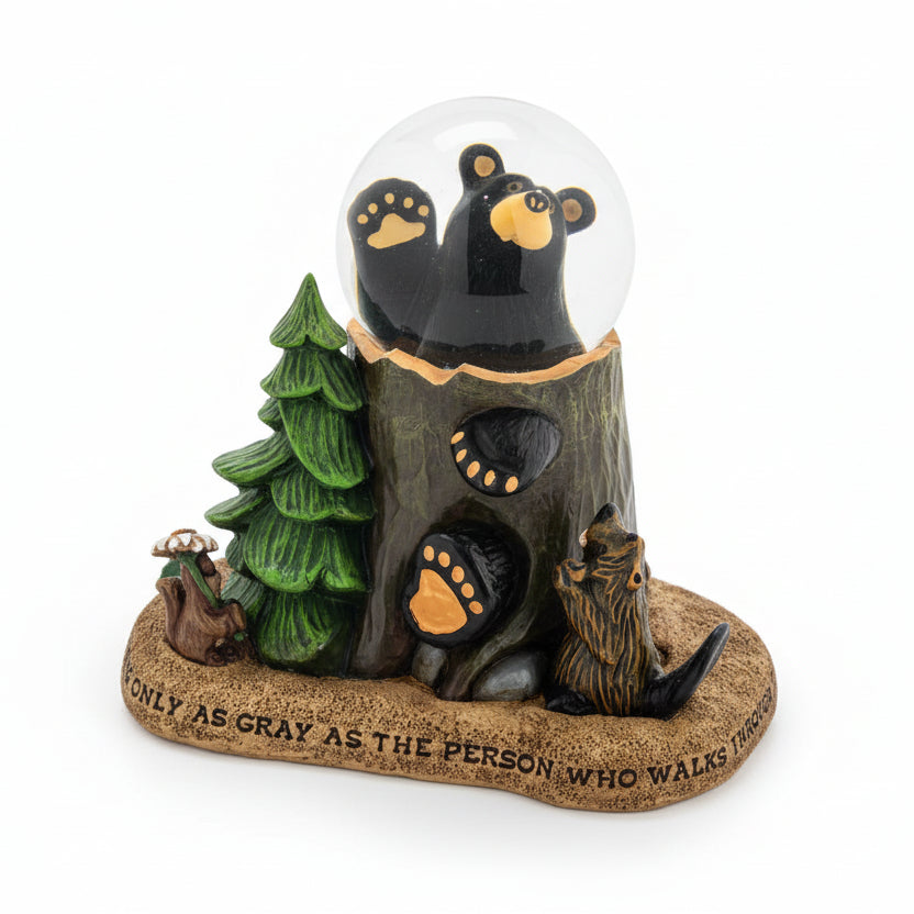 Glowing bear-themed snow globe with trees and footprints on a white background