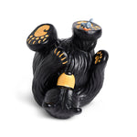 Black bear figurine with yellow paws on a white background