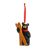 Bear ornament with skis and a red scarf on a white background