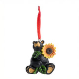 Black bear ornament holding a sunflower with a red ribbon on a white background