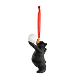 Bear ornament holding a volleyball with a red string on a white background