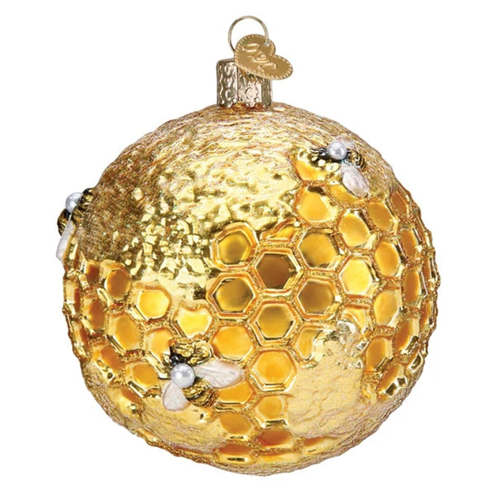 Gold Christmas ornament with honeycomb design and bees on a white background