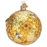 Gold Christmas ornament with honeycomb design and bees on a white background