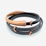 Black leather bracelet with rose gold accents on a white background
