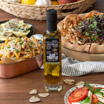 Olivelle Black Truffle oil bottle with a variety of food items on a wooden table