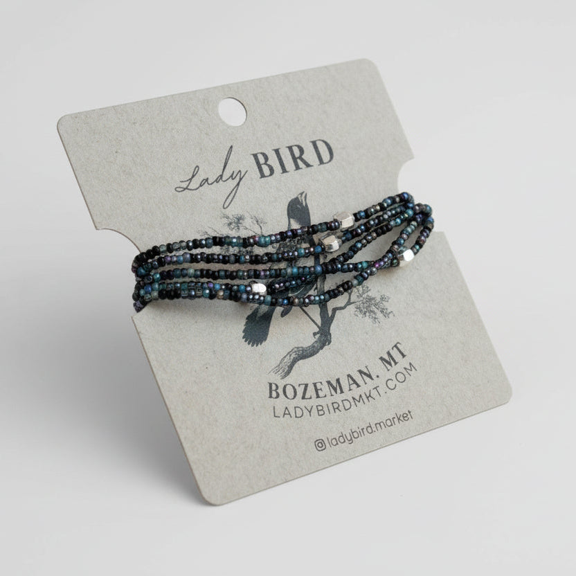 Set of beaded bracelets on a 'Lady Bird' branded card with a gray background