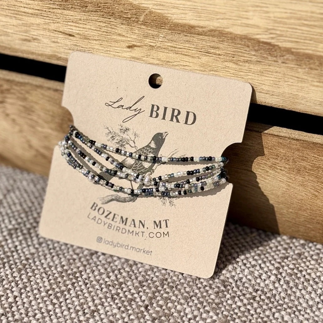Set of beaded bracelets on a 'Lady Bird' branded card with a wooden background