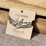 Set of beaded bracelets on a 'Lady Bird' branded card with a wooden background