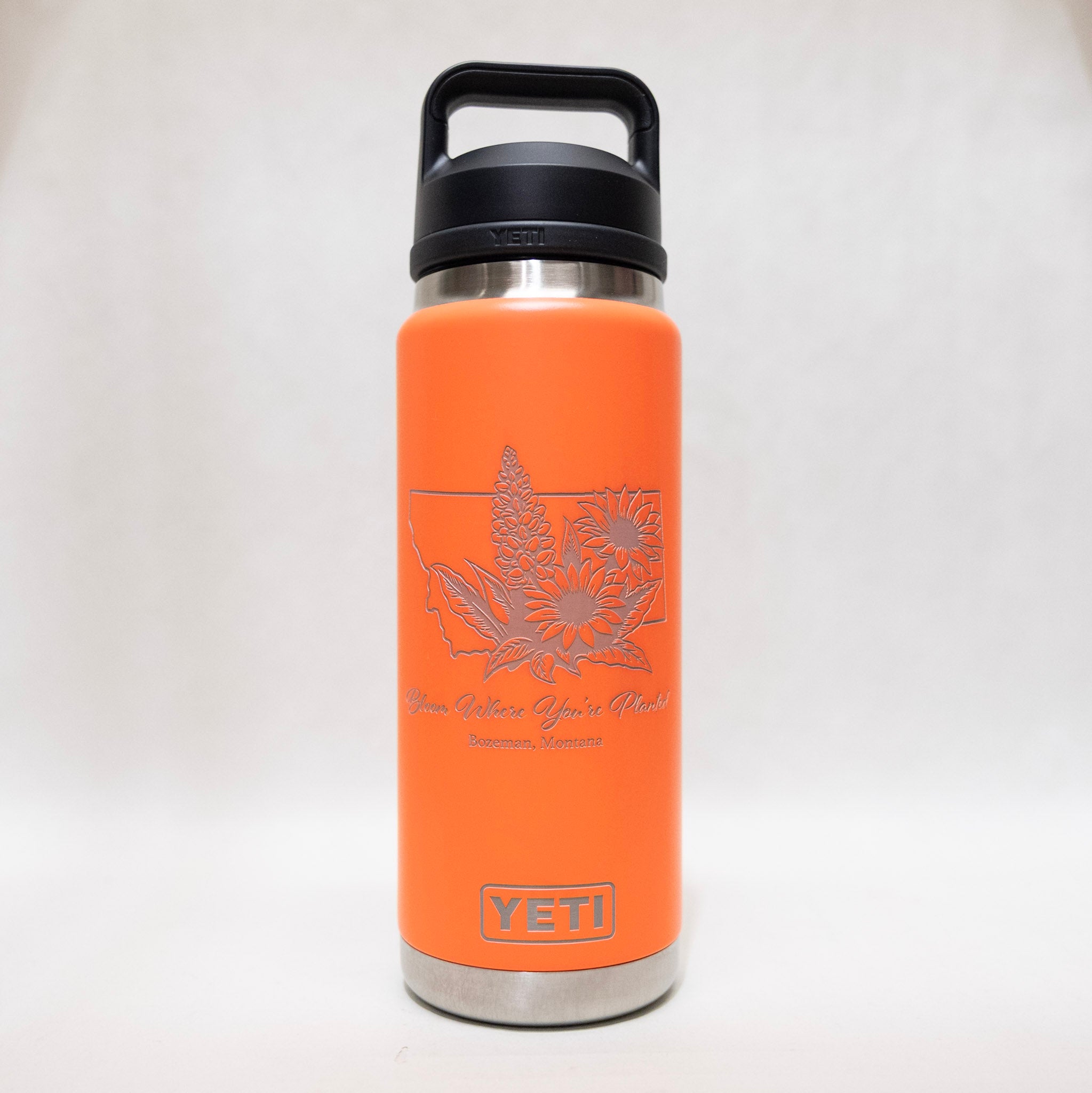 Orange YETI water bottle with floral design and text on a white background