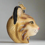 Glass ornament shaped like a bobcat head with a gold background
