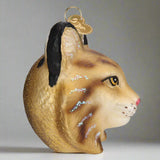 Glass ornament shaped like a bobcat head with a gold background