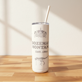 Tumbler with 'Bozeman, Montana' text and building illustration on a wooden surface.
