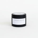 Black candle jar with 'Cameron Bridge' label on a white surface