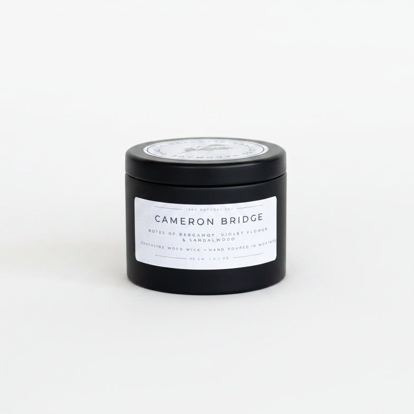 Black candle jar with 'Cameron Bridge' label on a white surface
