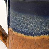 Close-up of a ceramic mug with blue and brown glaze