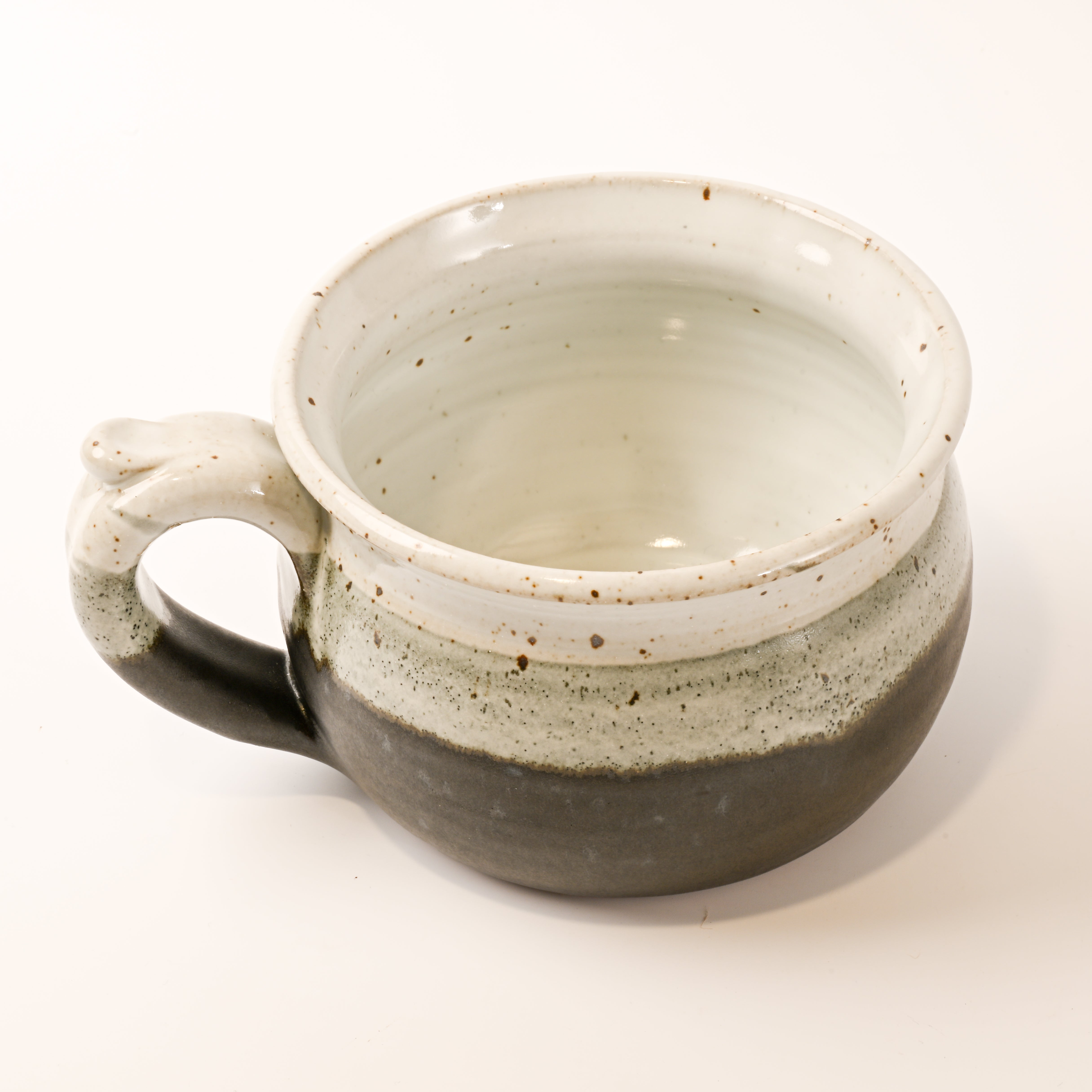 Ceramic bowl with speckled glaze on a white background