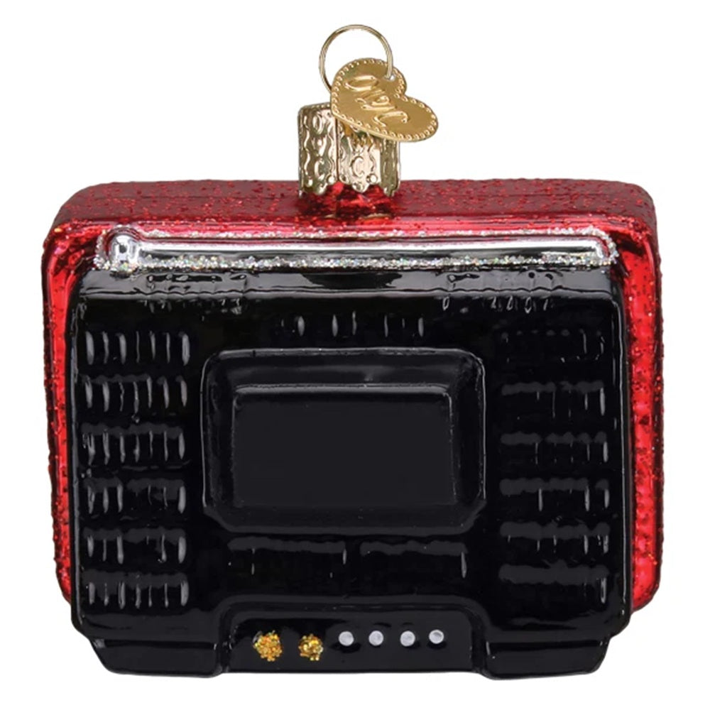 A vintage television-shaped Christmas ornament with a textured red glitter frame, a glossy black screen and front panel, and a gold hanging loop with a decorative tag at the top, shown on a plain white background.
