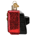 Decorative ornament resembling a vintage televsion with red glittery body and black accents on a white background.